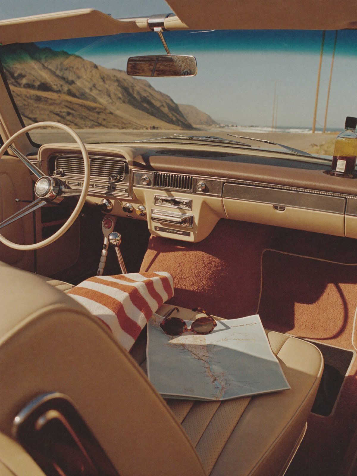 The convertible bench seat with a road map, sunglasses and a striped towel on PCH