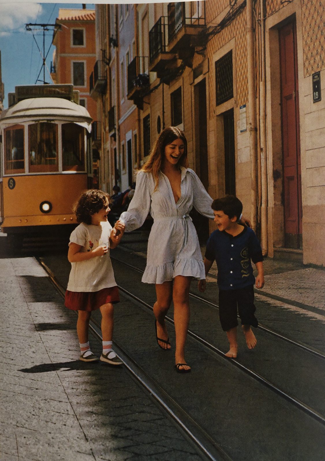 Ana Ferreira with her two children on a Lisbon tram street