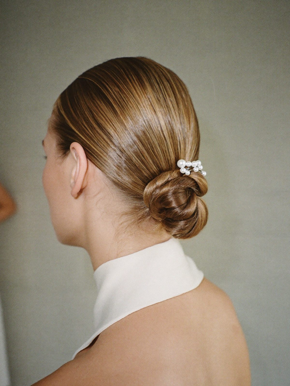 Sleek low bridal chignon from behind