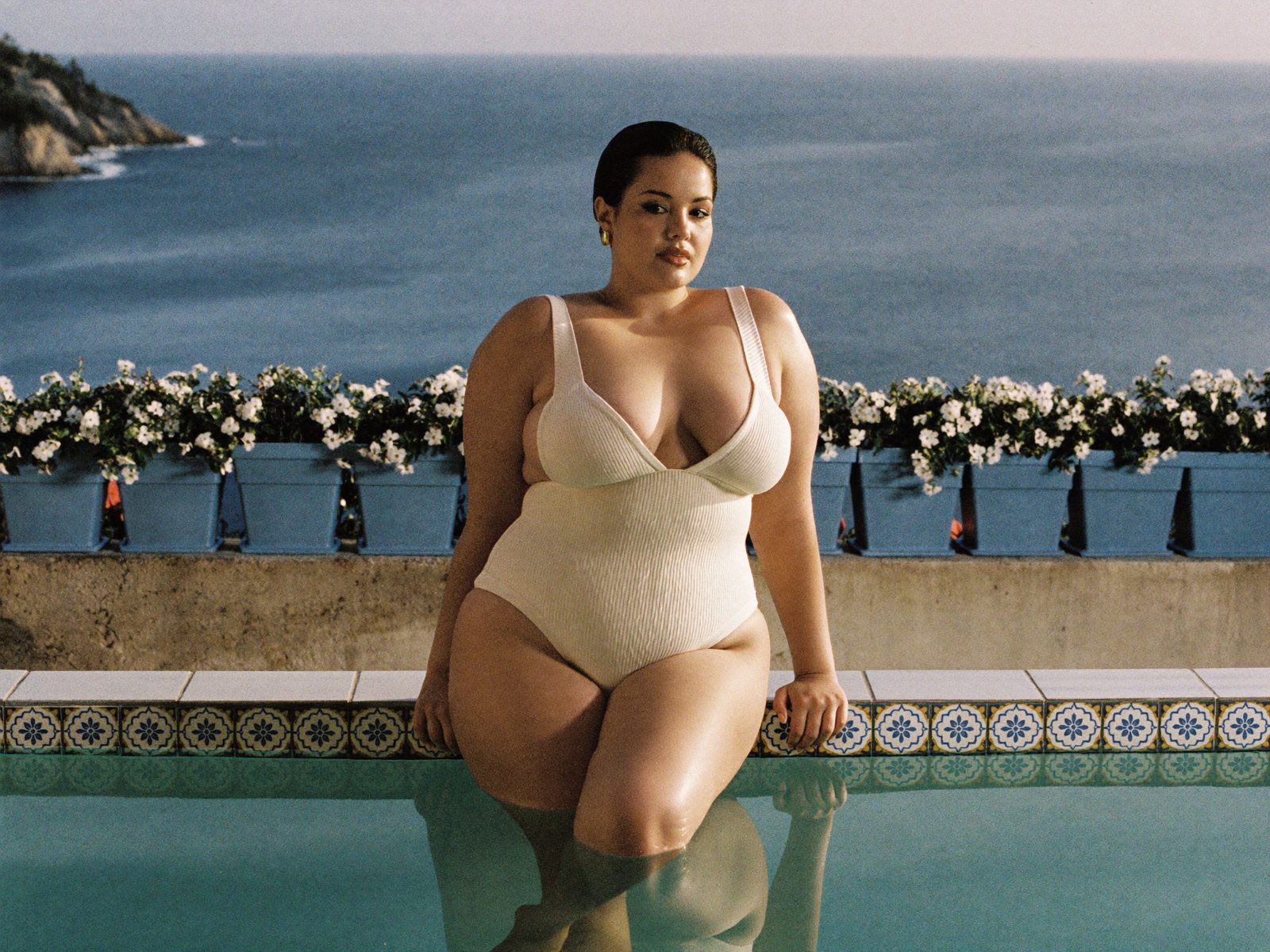Curvy model in The Starlet one-piece by a tiled pool in Capri